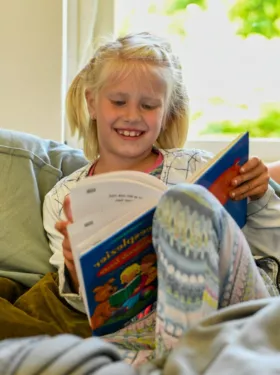 Nadine leest een boek op de bank